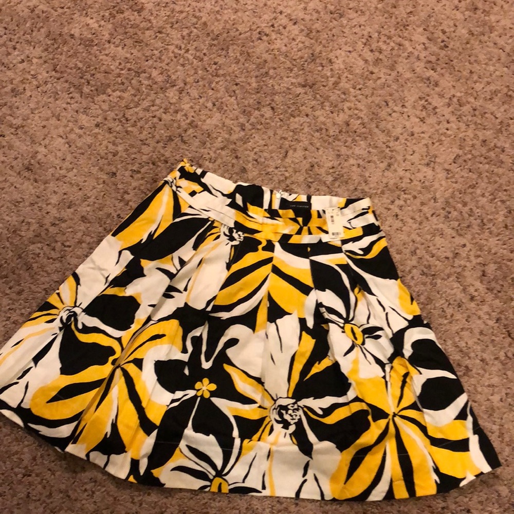 Brand new skirt with yellow, black and white flowers in size 10